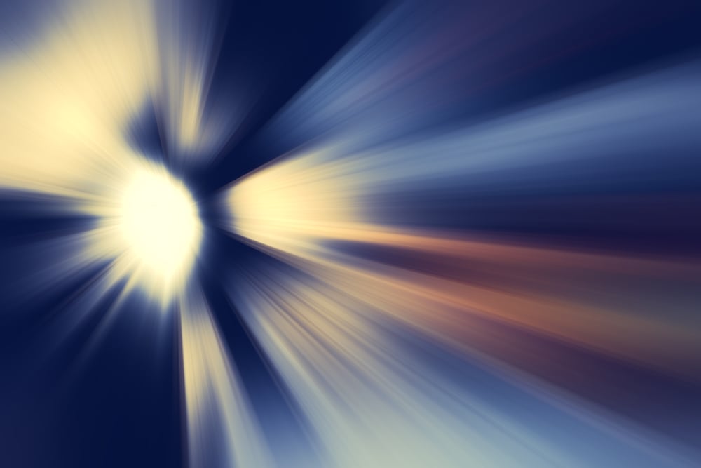 Abstract with radial blur of a bright source of light rays, like a glowing object traveling in outer space