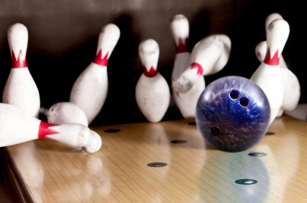 Bowling strike - ball hitting pins in the alley