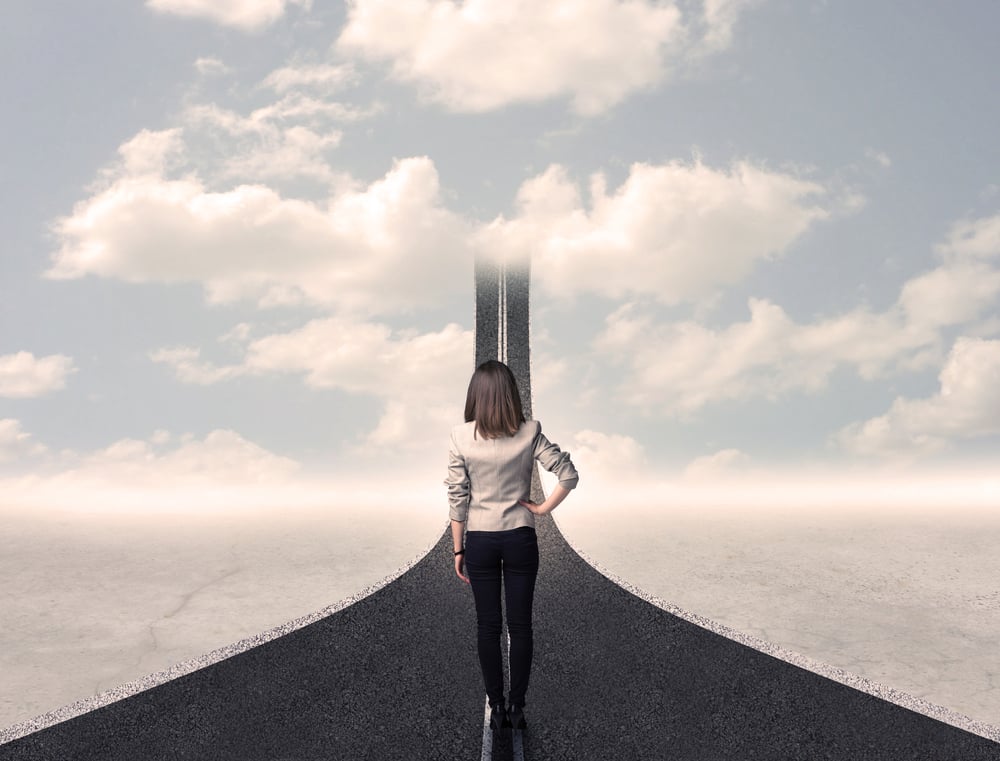 Business woman looking at road that goes up in the sky concept