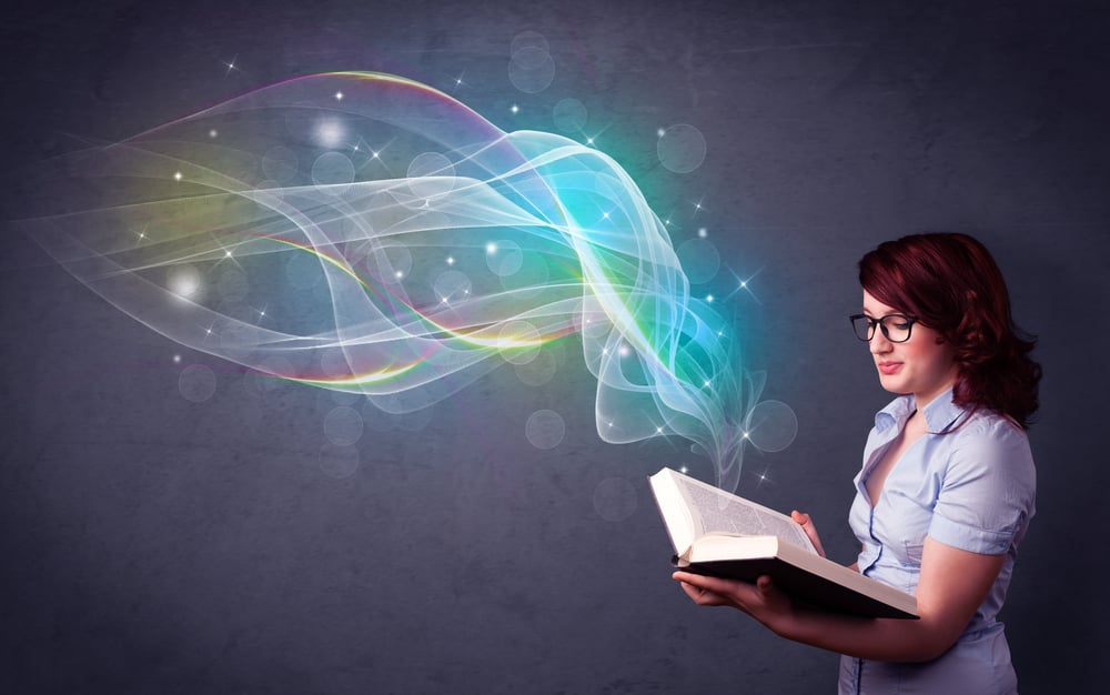 Casual young woman holding book with rainbow waves flying out of it