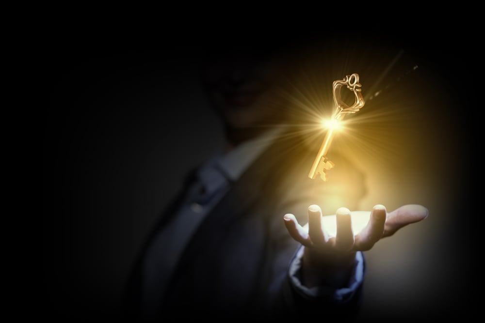 Close up image of business person holding shining key