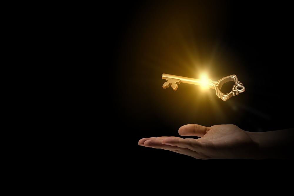 Close up of human hand holding golden key