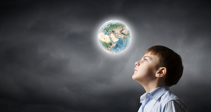 Little boy of school age looking at Earth planet. Elements of this image are furnished by NASA