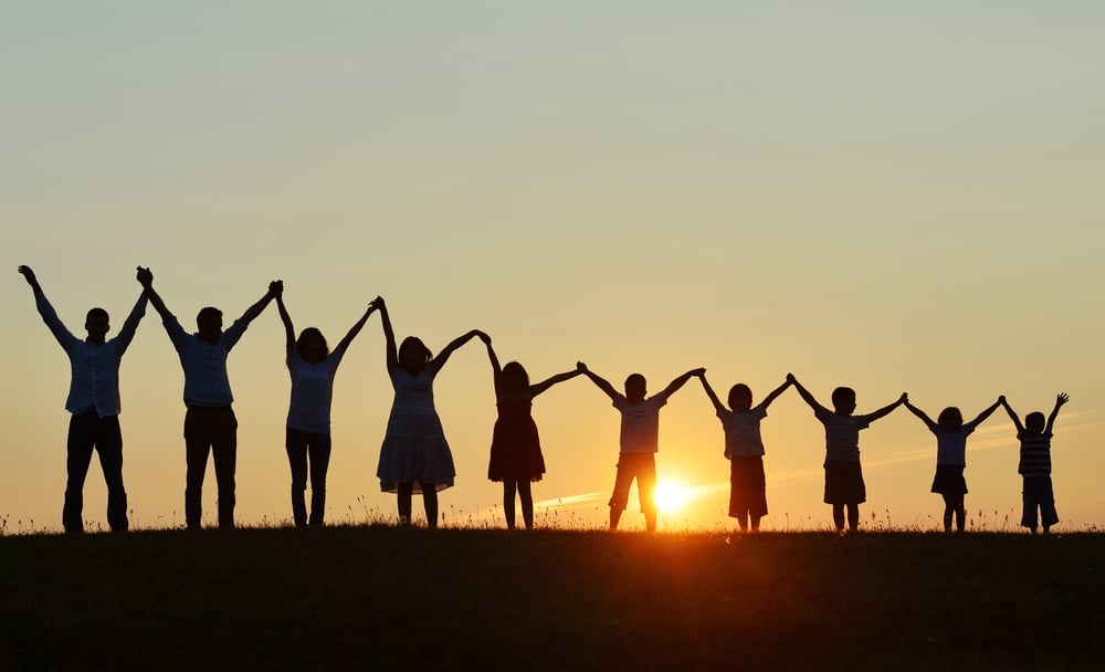 People silhouettes on sunset meadow having fun