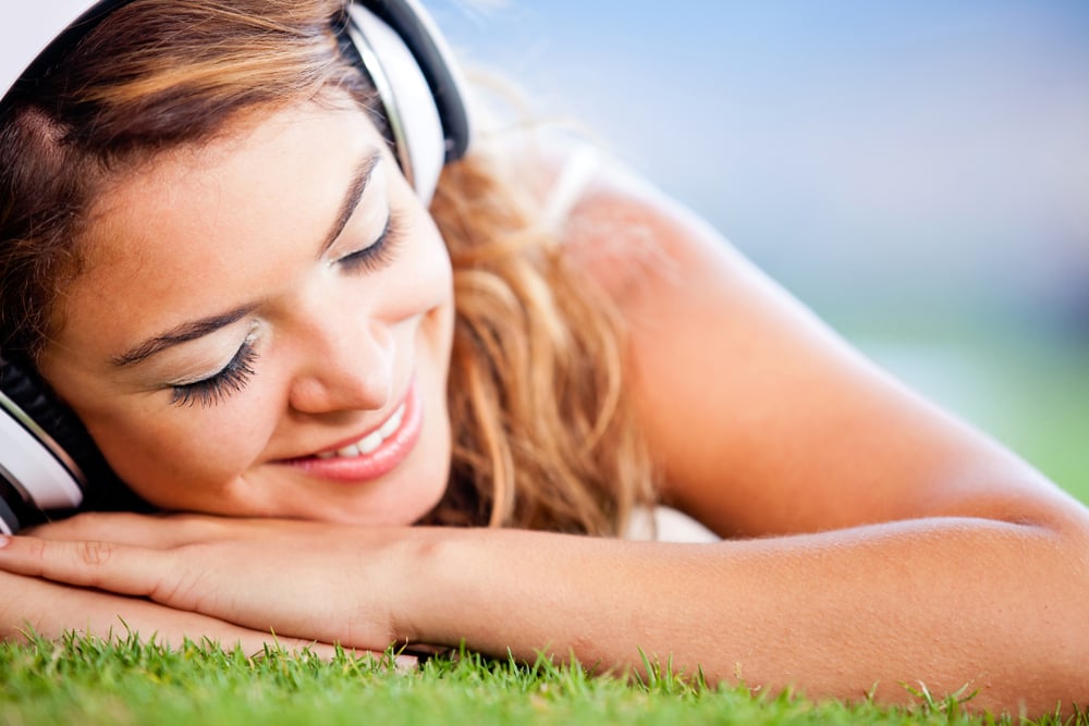 Relaxed woman lying on the floor and listening to music