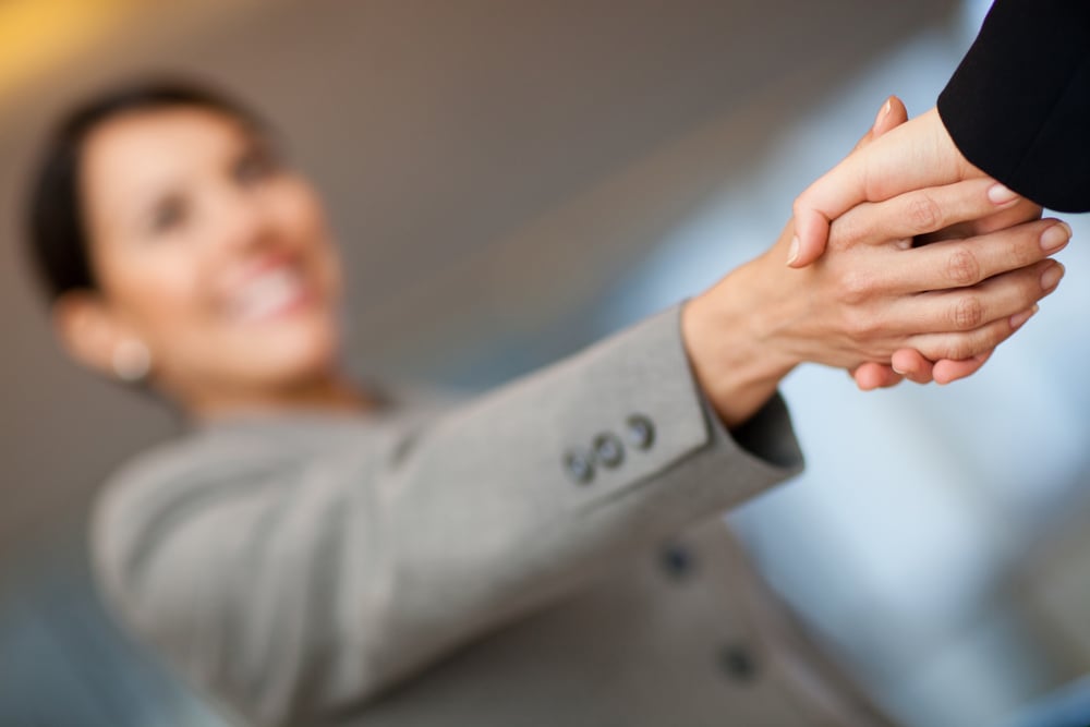 Welcoming business woman giving a handshake and smiling